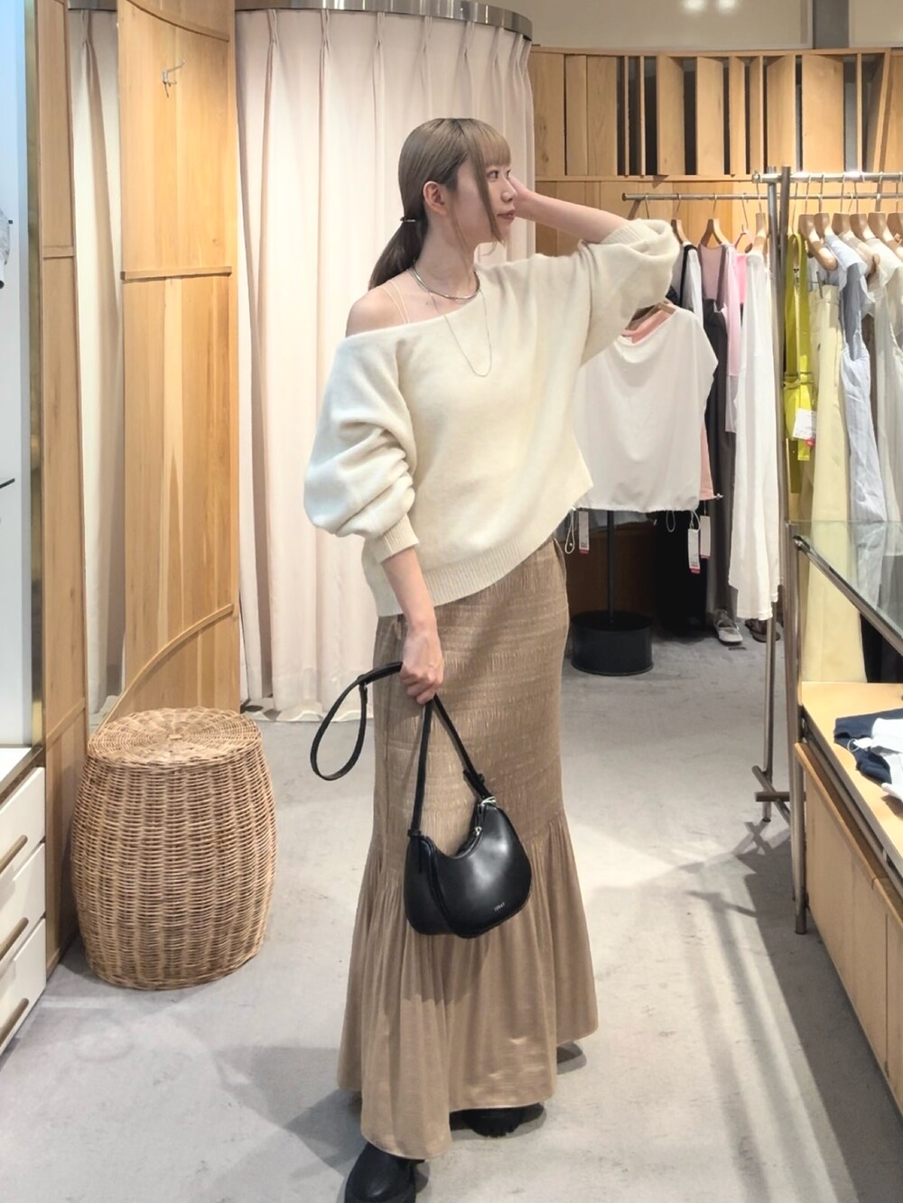 ホワイト系のニット/セーター、ベージュ系のスカート、ブラック系のブーツを着用したレディースの秋コーディネートの2枚目の写真