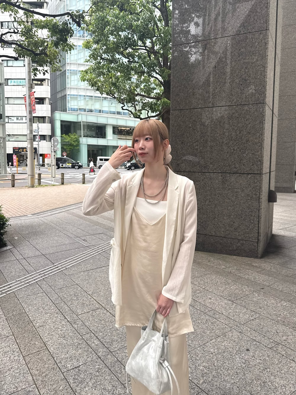 ホワイト系のキャミソール、ベージュ系のシャツ/ブラウス、ホワイト系のテーラードジャケットを着用したレディースの夏コーディネートの3枚目の写真