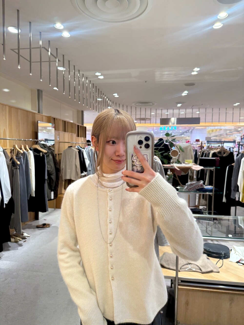 ホワイト系のカーディガン/ボレロ、ホワイト系のTシャツ/カットソー、ブラック系のトートバッグを着用したレディースの冬コーディネートの2枚目の写真