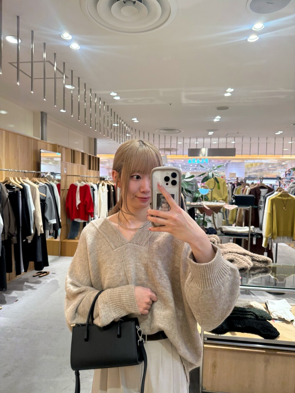 ベージュ系のニット/セーター、ブラック系のトートバッグ、ベージュ系のスラックスを着用したレディースの冬コーディネートの2枚目の写真