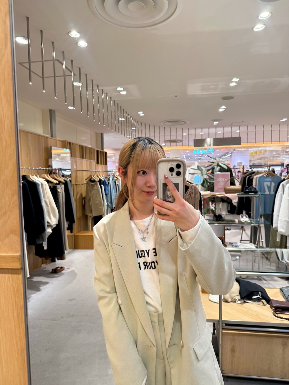 ホワイト系のTシャツ/カットソー、ベージュ系のテーラードジャケット、ブラック系のトートバッグを着用したレディースの春コーディネートの2枚目の写真