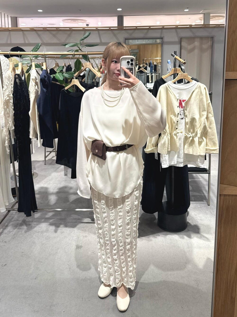 ベージュ系のスカート、ホワイト系のシャツ/ブラウス、ブラウン系のベルトを着用したレディースの春コーディネートの3枚目の写真