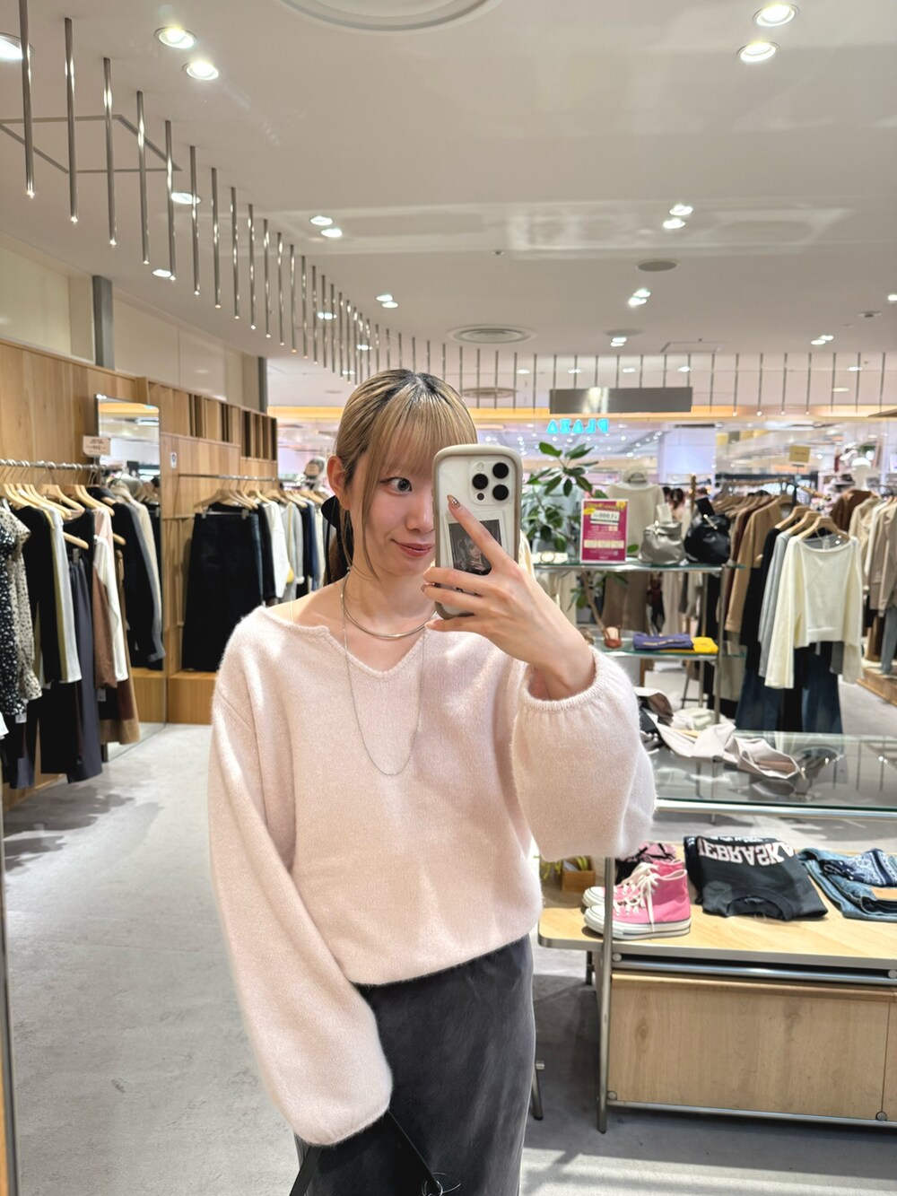 ピンク系のニット/セーター、グレー系のスカート、ブラック系のブーツを着用したレディースの秋コーディネートの3枚目の写真