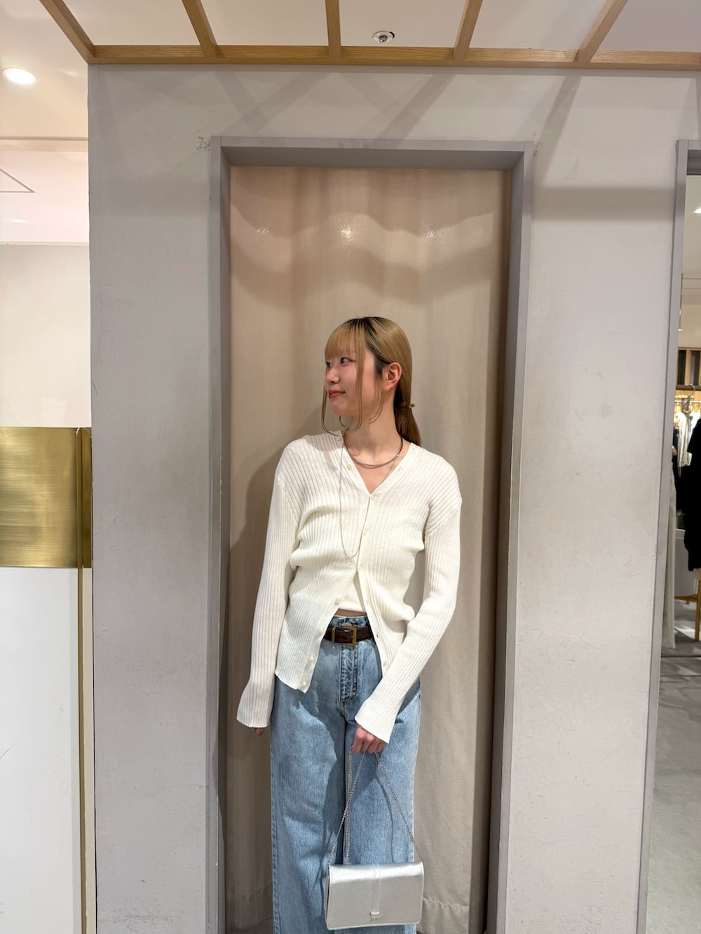 ホワイト系のカーディガン/ボレロ、ブルー系のデニムパンツを着用したレディースの春コーディネートの2枚目の写真