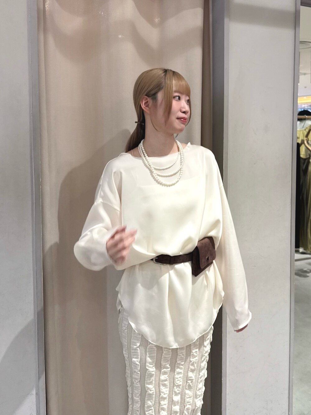 ベージュ系のスカート、ホワイト系のシャツ/ブラウス、ブラウン系のベルトを着用したレディースの春コーディネートの2枚目の写真