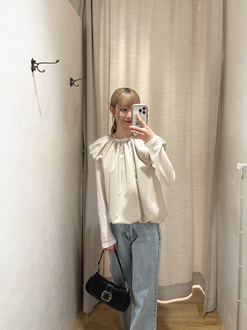 ブラック系のハンドバッグ、ホワイト系のシャツ/ブラウス、ホワイト系のTシャツ/カットソーを着用したレディースの春コーディネートの2枚目の写真