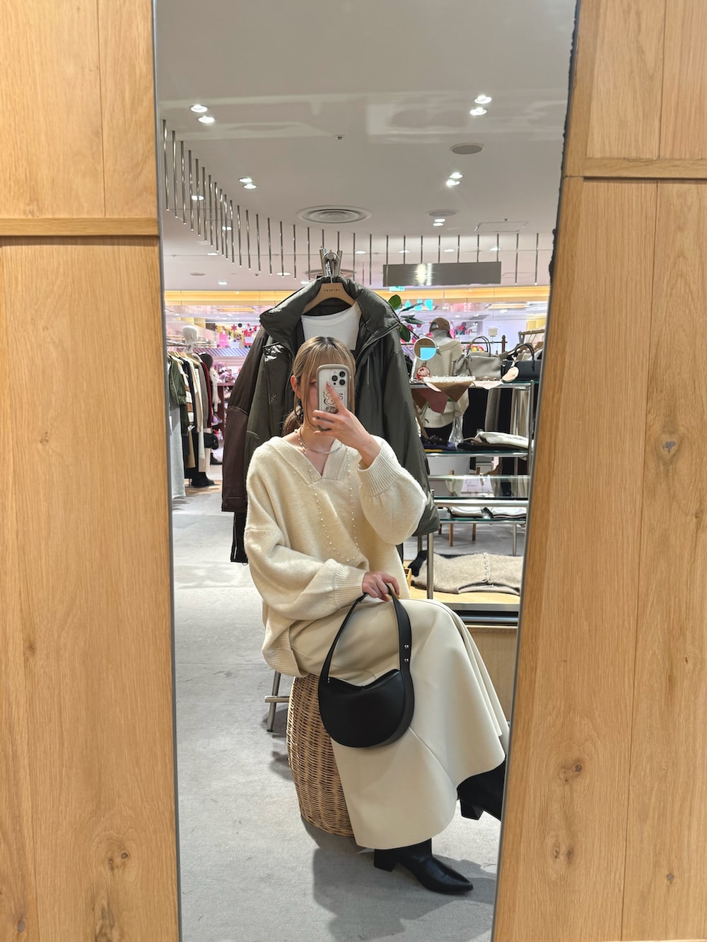 ホワイト系のニット/セーター、ブラック系のトートバッグ、ベージュ系のスカートを着用したレディースの冬コーディネートの3枚目の写真
