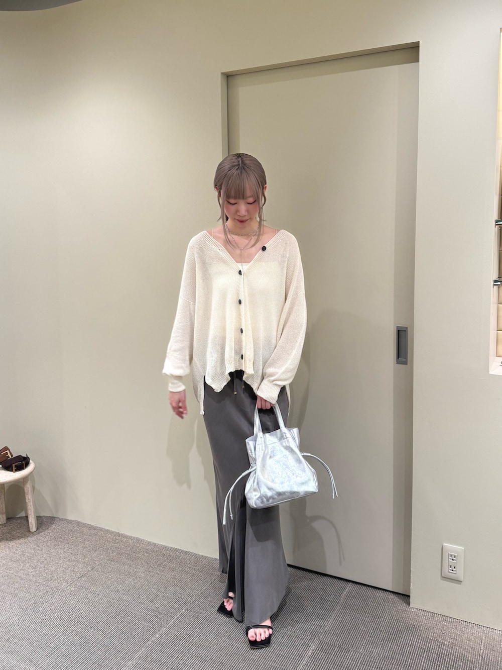 ホワイト系のカーディガン/ボレロ、シルバー系のトートバッグ、ブラウン系のスカートを着用したレディースの夏コーディネートの3枚目の写真