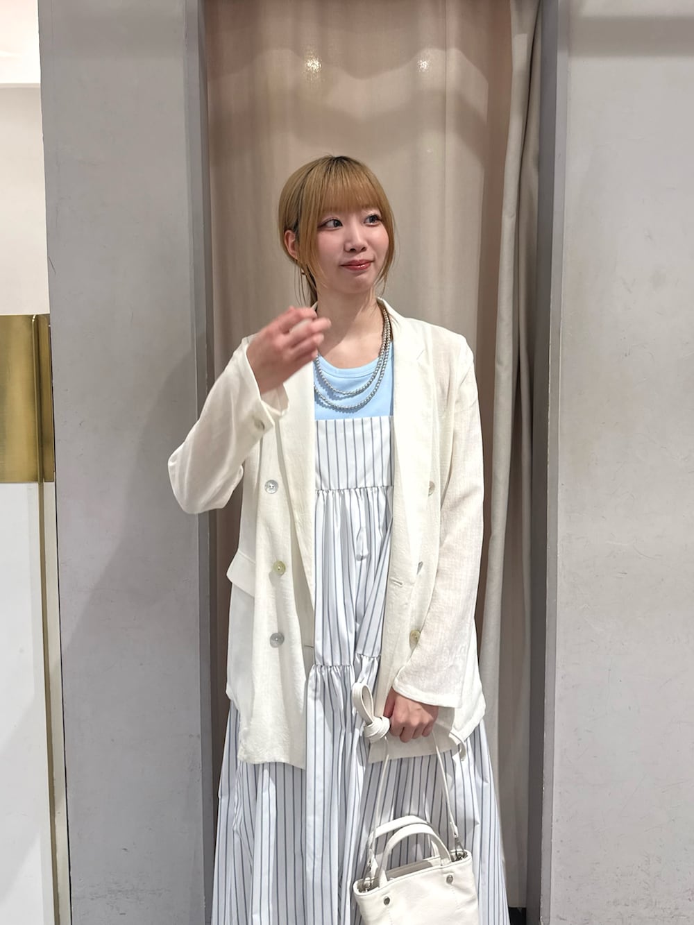 ホワイト系のトートバッグ、ホワイト系のワンピース、ホワイト系のテーラードジャケットを着用したレディースの春コーディネートの2枚目の写真