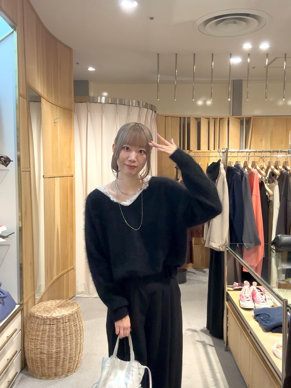 ブラック系のスラックス、シルバー系のトートバッグ、ブラック系のパンプスを着用したレディースの秋コーディネートの2枚目の写真