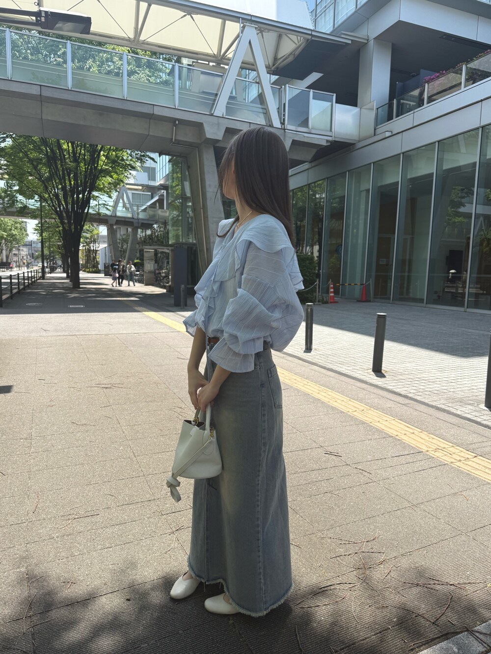 ブルー系のシャツ/ブラウス、ホワイト系のトートバッグ、ブルー系のスカートを着用したレディースの夏コーディネートの2枚目の写真