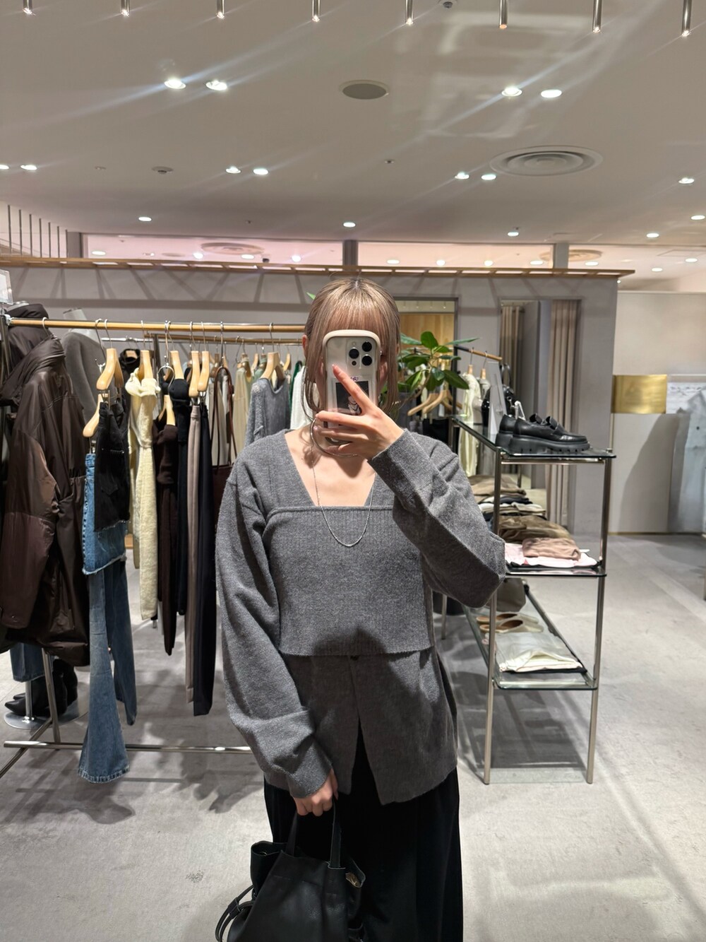 グレー系のカーディガン/ボレロ、ゴールド系のパンプス、ブラック系のトートバッグを着用したレディースの秋コーディネートの2枚目の写真