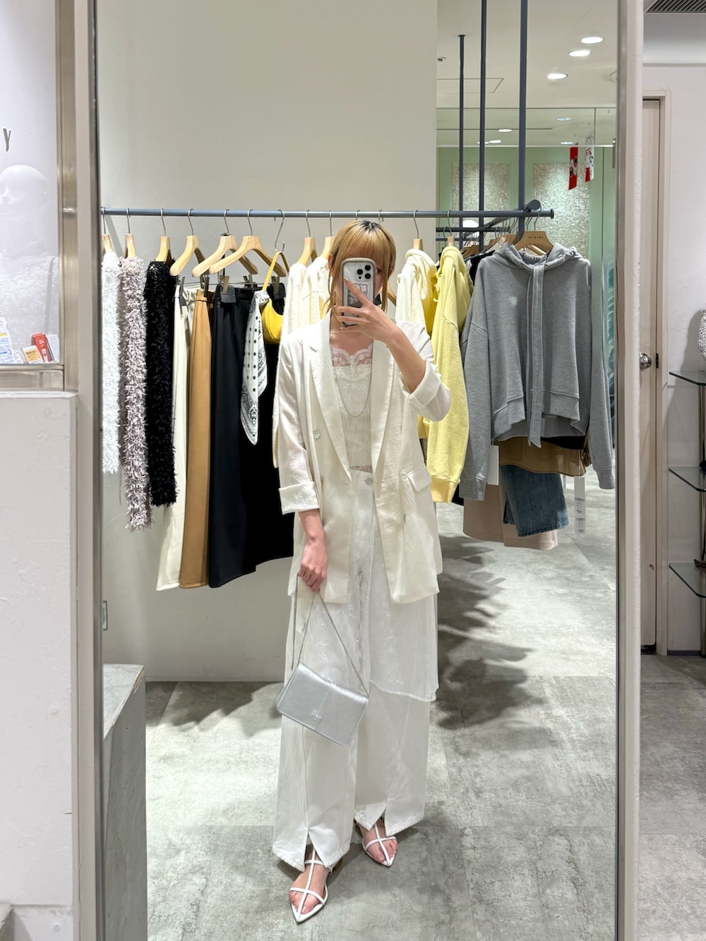 ホワイト系のチュニック、ホワイト系のテーラードジャケット、ホワイト系のデニムパンツを着用したレディースの春コーディネートの2枚目の写真