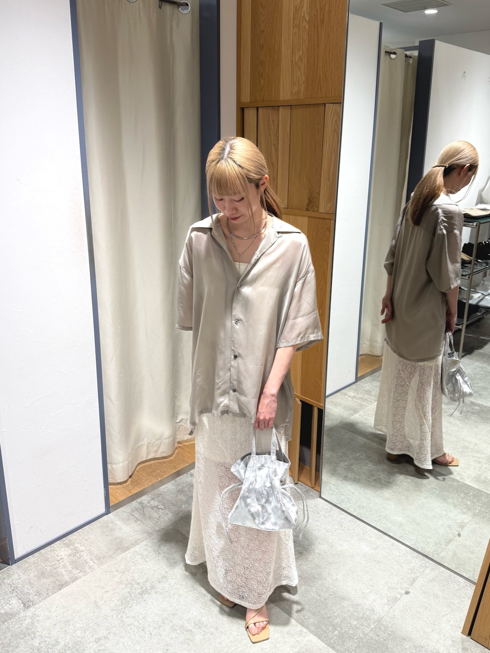 ベージュ系のシャツ/ブラウス、ホワイト系のスカート、シルバー系のトートバッグを着用したレディースの春コーディネートの2枚目の写真