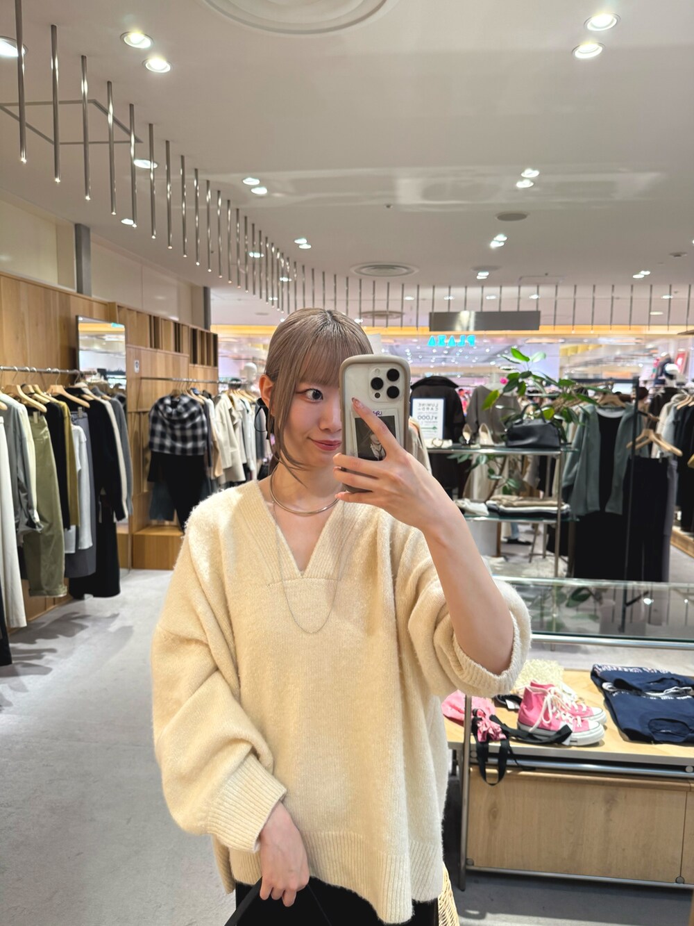 ホワイト系のニット/セーター、ブラウン系のスカート、ゴールド系のパンプスを着用したレディースの秋コーディネートの2枚目の写真