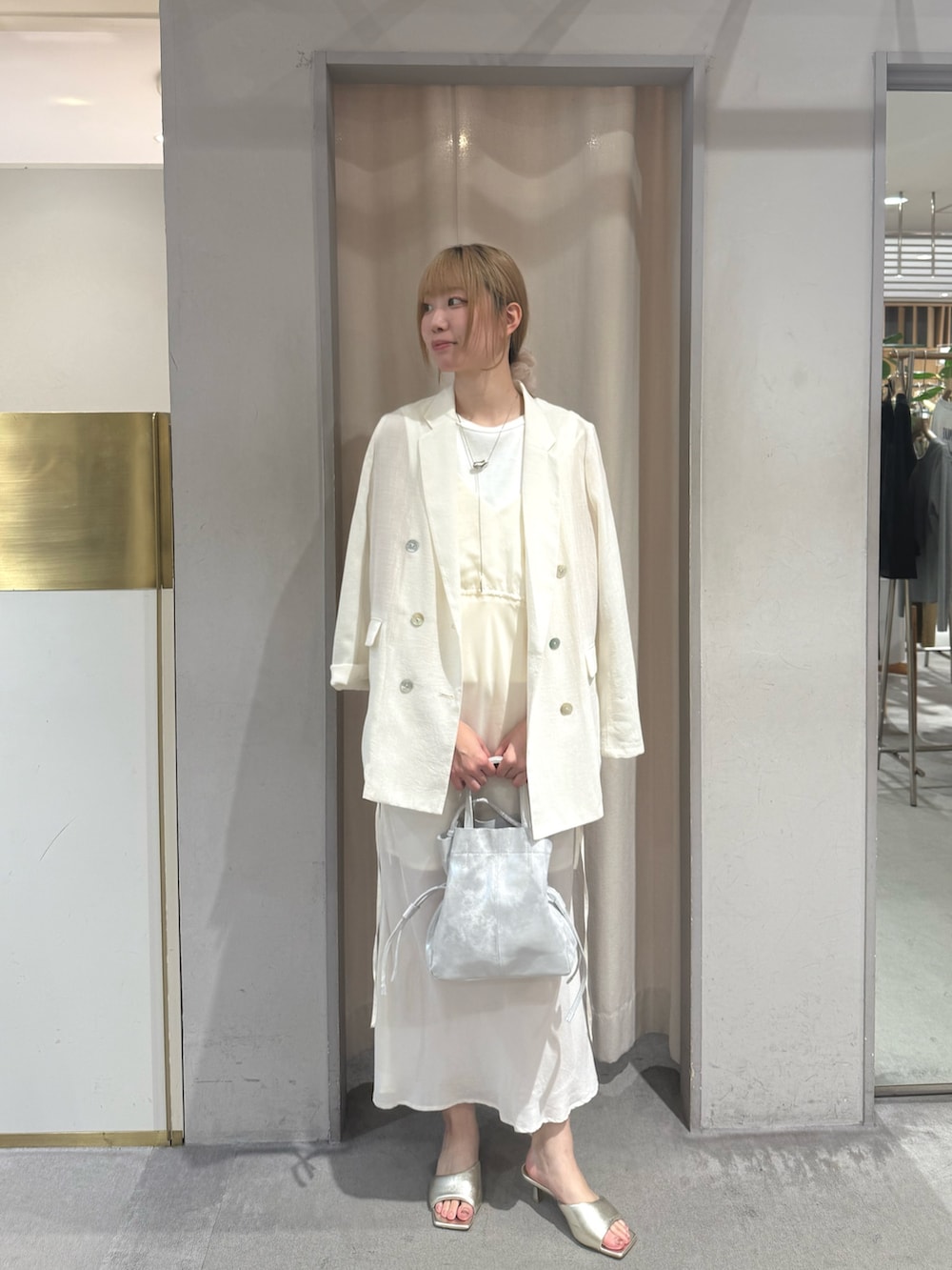 ゴールド系のサンダル、ホワイト系のTシャツ/カットソー、シルバー系のトートバッグを着用したレディースの夏コーディネートの3枚目の写真