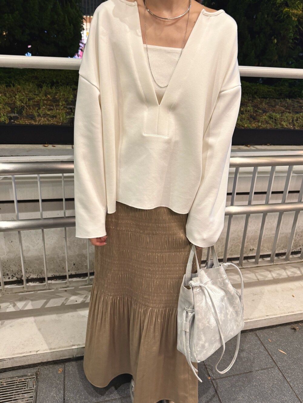 ホワイト系のスウェット、ホワイト系のキャミソール、ベージュ系のスカートを着用したレディースの秋コーディネートの2枚目の写真