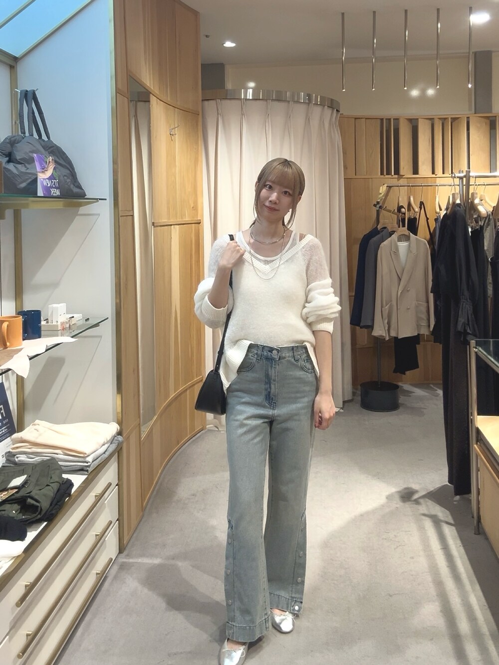 ホワイト系のニット/セーター、ブルー系のデニムパンツ、シルバー系のパンプスを着用したレディースの秋コーディネートの2枚目の写真