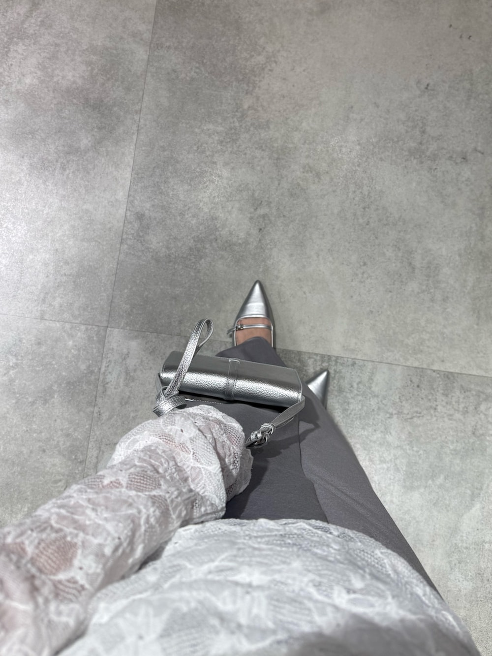 グレー系のニット/セーター、ホワイト系のTシャツ/カットソー、グレー系のスカートを着用したレディースの冬コーディネートの3枚目の写真