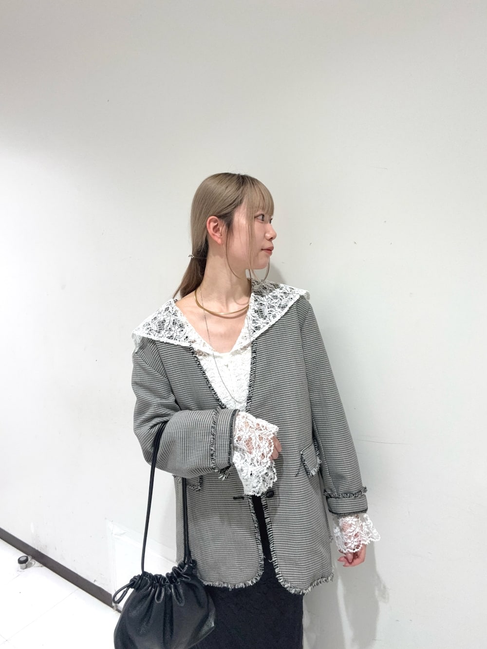 ホワイト系のシャツ/ブラウス、ブラック系のテーラードジャケット、ブラック系のショルダーバッグを着用したレディースの秋コーディネートの4枚目の写真