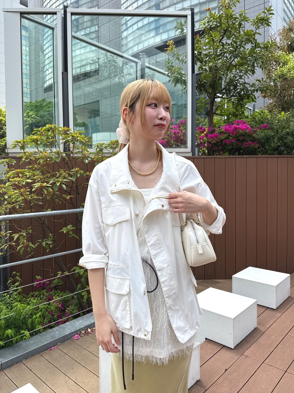 イエロー系のスカート、ホワイト系のトートバッグ、ホワイト系のその他アウターを着用したレディースの春コーディネートの2枚目の写真