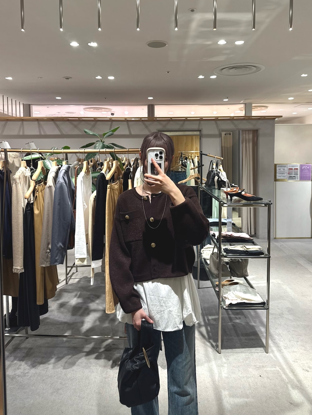 ブルー系のデニムパンツ、ホワイト系のシャツ/ブラウス、ブラウン系のカーディガン/ボレロを着用したレディースの秋コーディネートの2枚目の写真