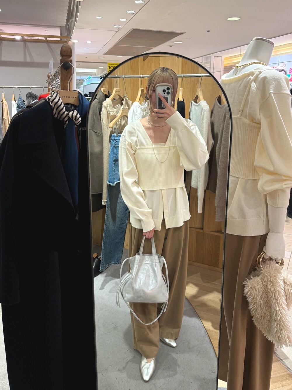 シルバー系のトートバッグ、ベージュ系のスラックス、ゴールド系のパンプスを着用したレディースの秋コーディネートの3枚目の写真