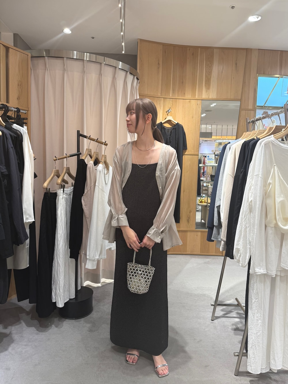 ブラック系のワンピース、グレー系のシャツ/ブラウス、シルバー系のトートバッグを着用したレディースの夏コーディネートの2枚目の写真