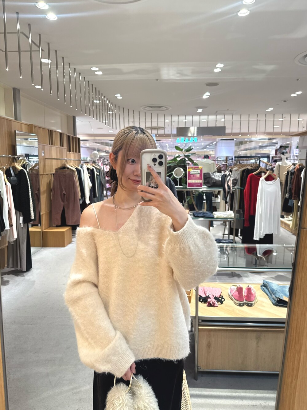 ブラウン系のスカート、ブラック系のパンプス、ホワイト系のニット/セーターを着用したレディースの秋コーディネートの3枚目の写真