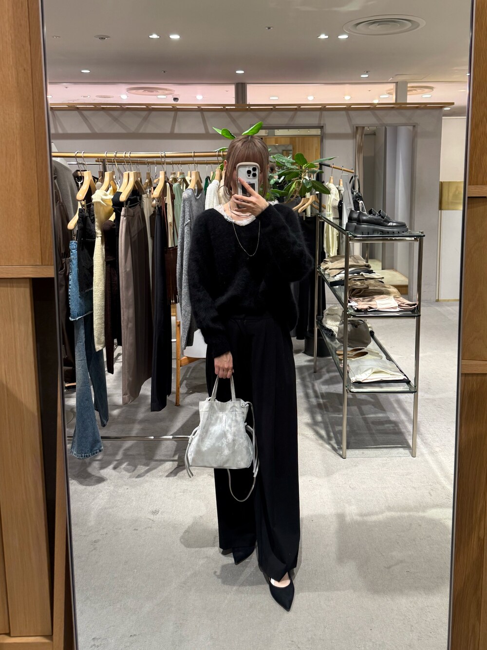 ブラック系のスラックス、シルバー系のトートバッグ、ブラック系のパンプスを着用したレディースの秋コーディネートの3枚目の写真