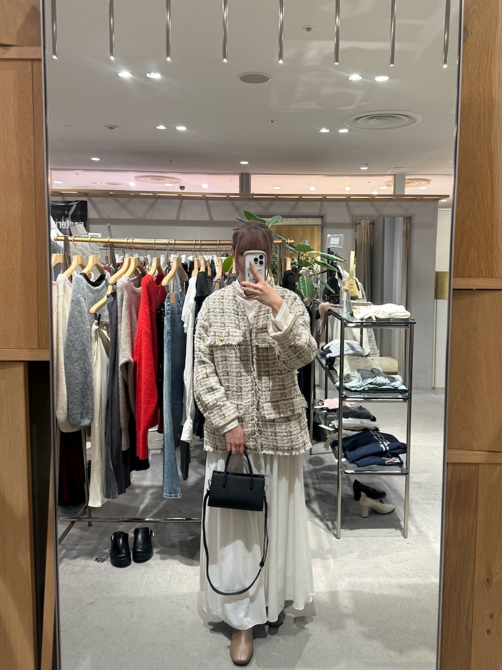 ホワイト系のその他アウター、ホワイト系のニット/セーター、ブラック系のトートバッグを着用したレディースの冬コーディネートの3枚目の写真