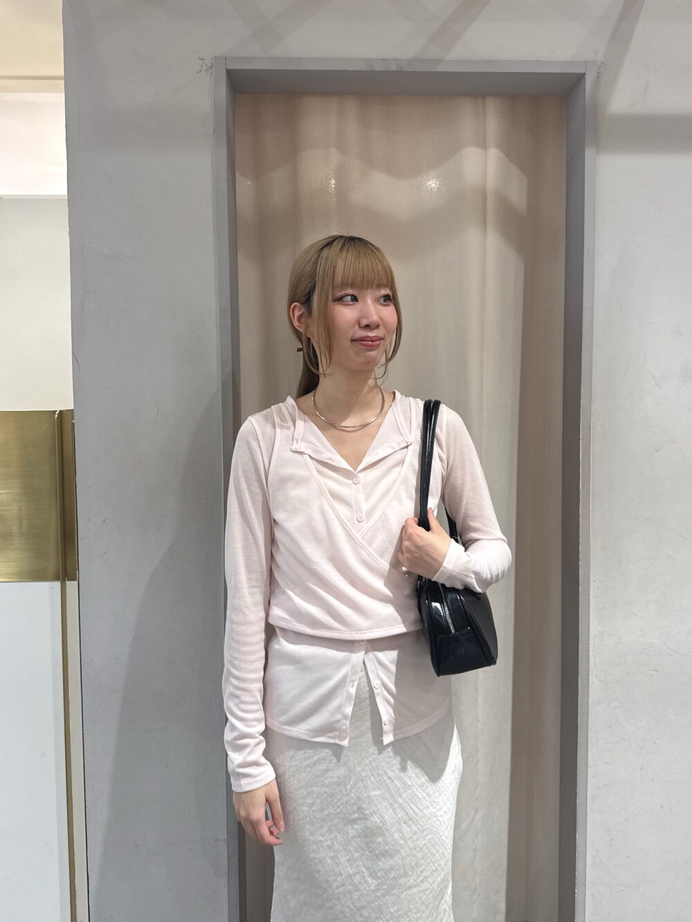 ホワイト系のスカート、ブラック系のサンダル、ブラック系のトートバッグを着用したレディースの夏コーディネートの3枚目の写真