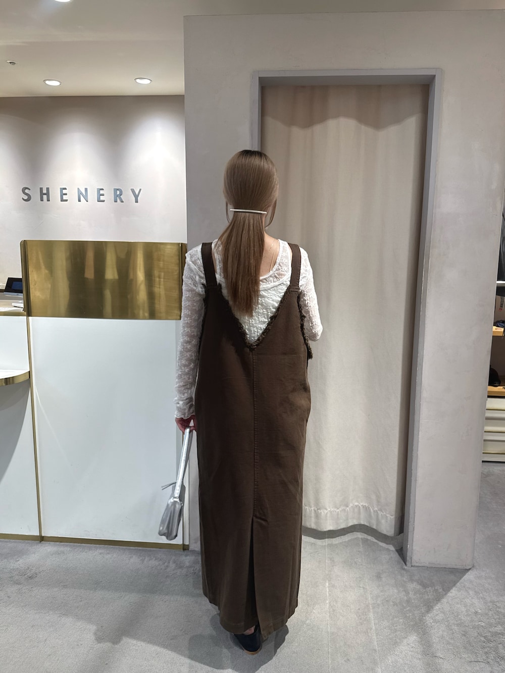 ブラウン系のワンピース、ホワイト系のTシャツ/カットソー、シルバー系のショルダーバッグを着用したレディースの夏コーディネートの3枚目の写真