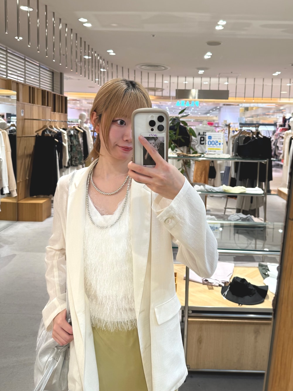 イエロー系のスカート、ゴールド系のサンダル、シルバー系のトートバッグを着用したレディースの夏コーディネートの4枚目の写真