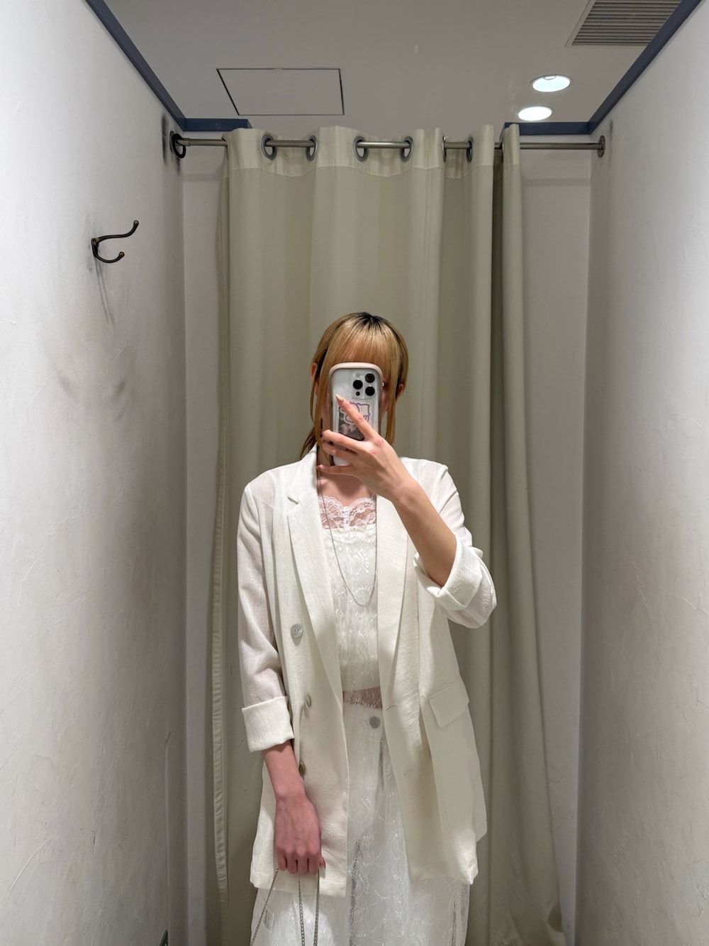 ホワイト系のチュニック、ホワイト系のテーラードジャケット、ホワイト系のデニムパンツを着用したレディースの春コーディネートの3枚目の写真