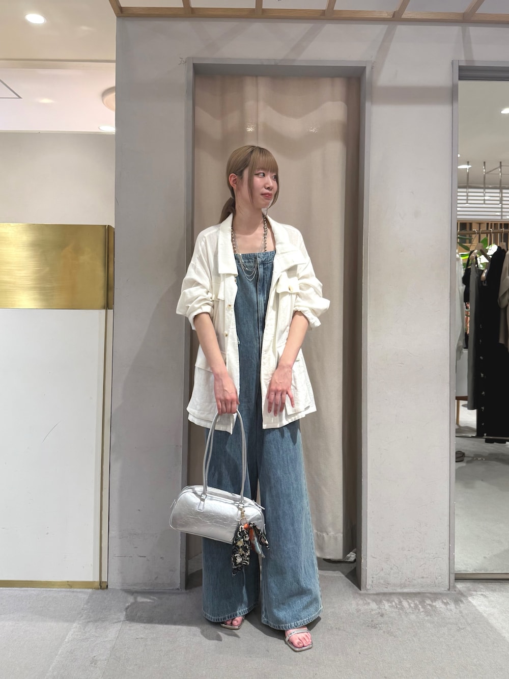 ホワイト系のその他アウター、ブルー系のサロペット/オーバーオール、シルバー系のトートバッグを着用したレディースの夏コーディネートの2枚目の写真