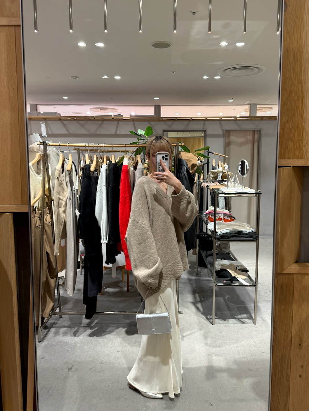 ベージュ系のニット/セーター、ホワイト系のスカートを着用したレディースの冬コーディネートの2枚目の写真