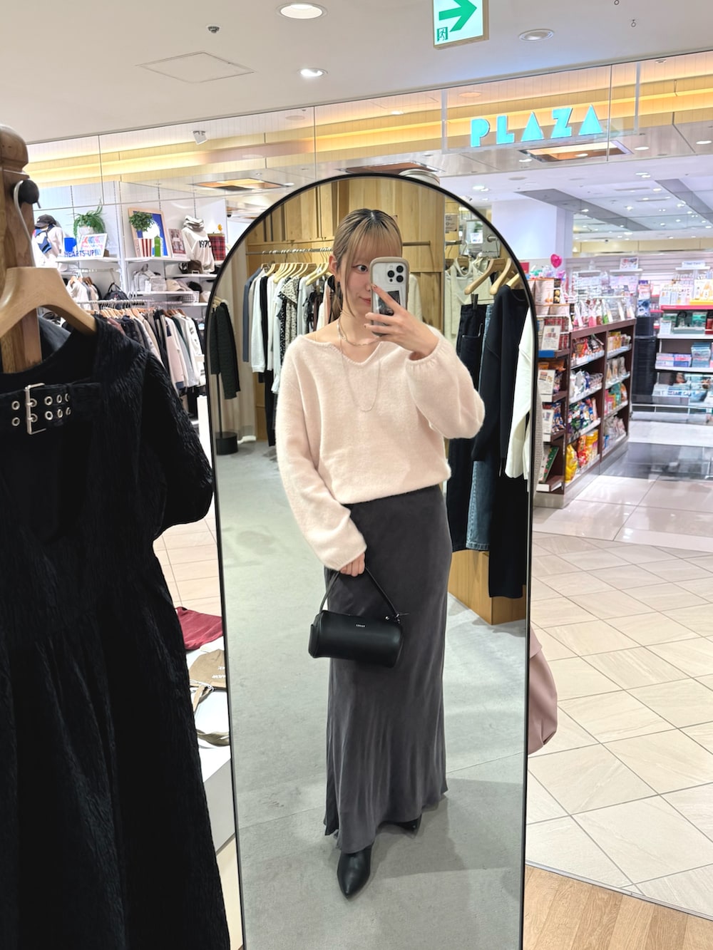 ピンク系のニット/セーター、グレー系のスカート、ブラック系のブーツを着用したレディースの秋コーディネートの2枚目の写真