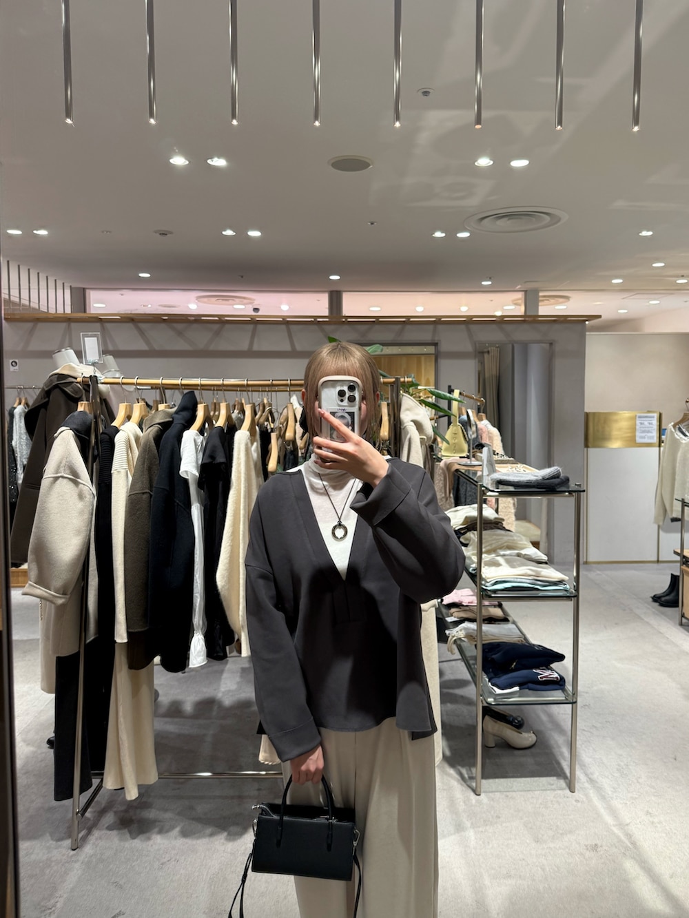 グレー系のスウェット、ホワイト系のTシャツ/カットソー、ブラック系のトートバッグを着用したレディースの冬コーディネートの2枚目の写真