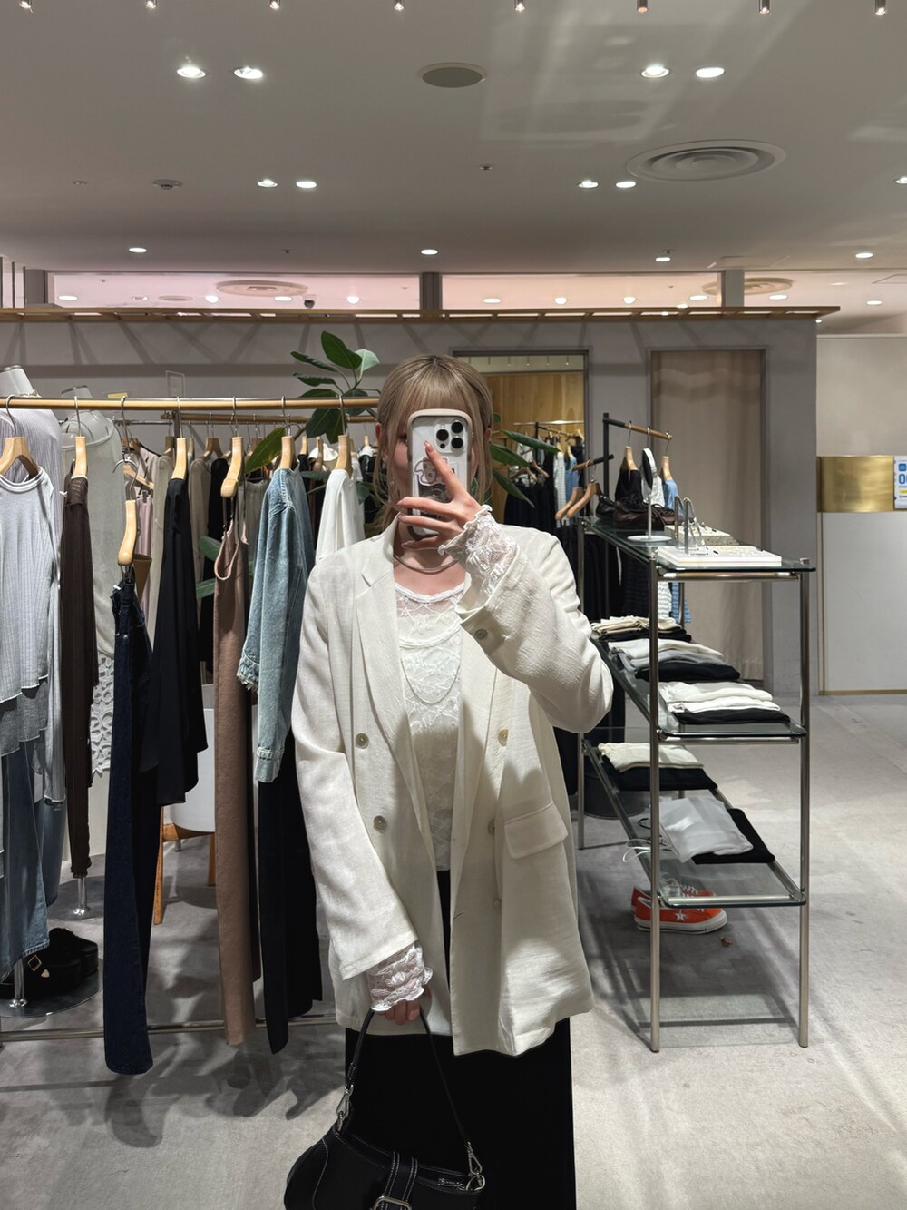 ホワイト系のTシャツ/カットソー、ホワイト系のテーラードジャケット、ブラック系のスカートを着用したレディースの春コーディネートの2枚目の写真