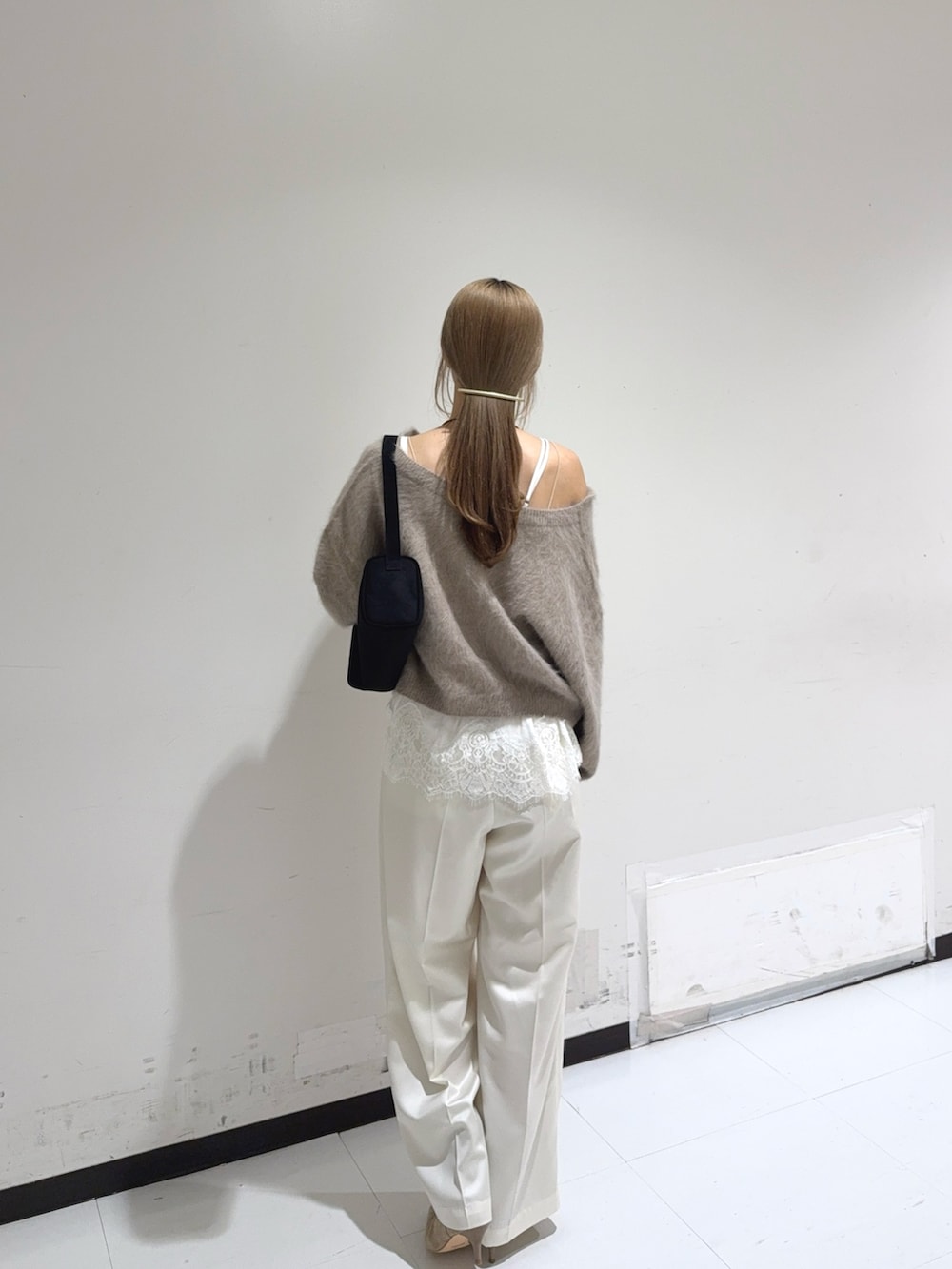イエロー系のニット/セーター、ブラック系のトートバッグ、ホワイト系のシャツ/ブラウスを着用したレディースの秋コーディネートの2枚目の写真