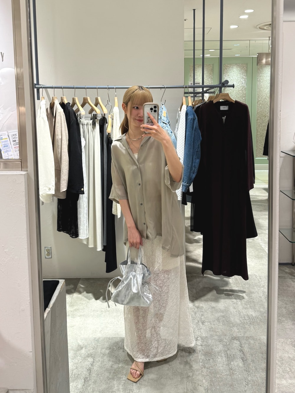 ベージュ系のシャツ/ブラウス、ホワイト系のスカート、シルバー系のトートバッグを着用したレディースの春コーディネートの3枚目の写真