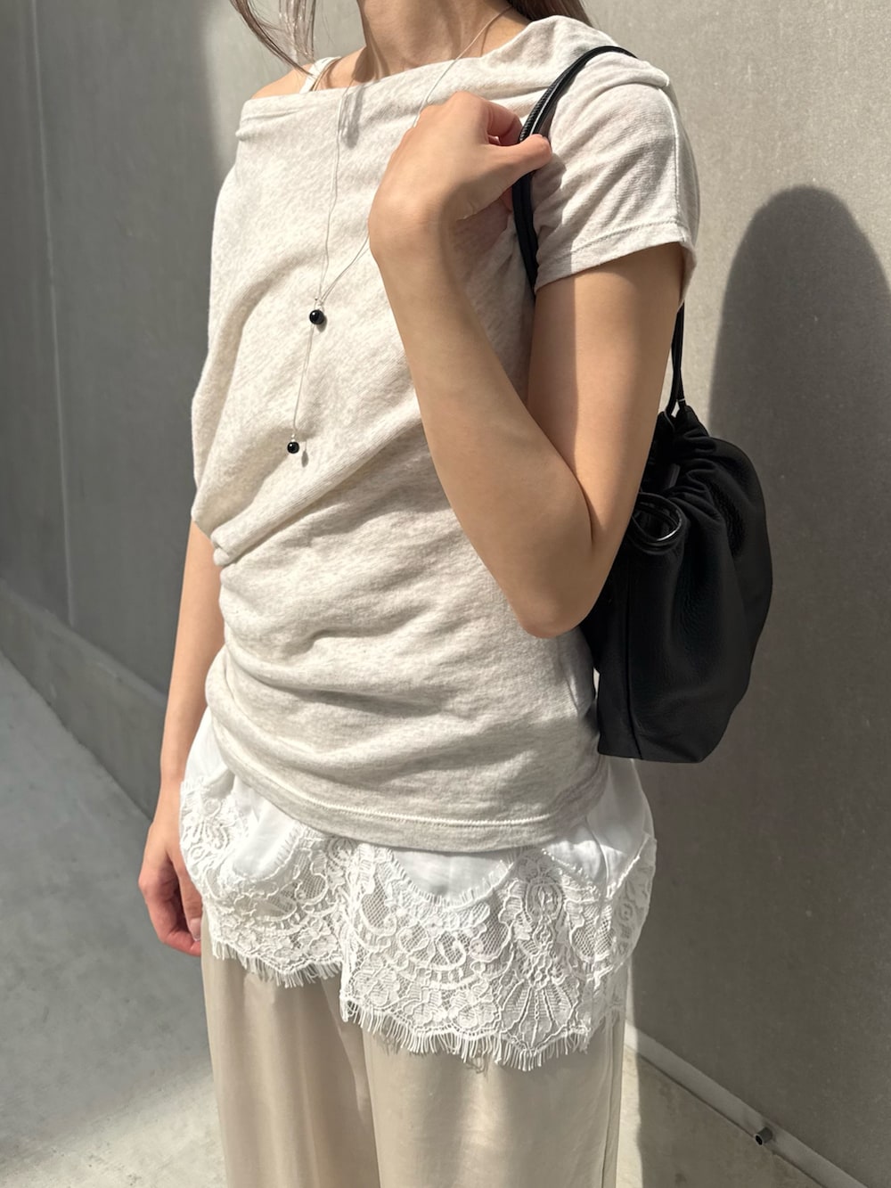 グレー系のTシャツ/カットソー、ブラック系のショルダーバッグ、ホワイト系のシャツ/ブラウスを着用したレディースの夏コーディネートの3枚目の写真