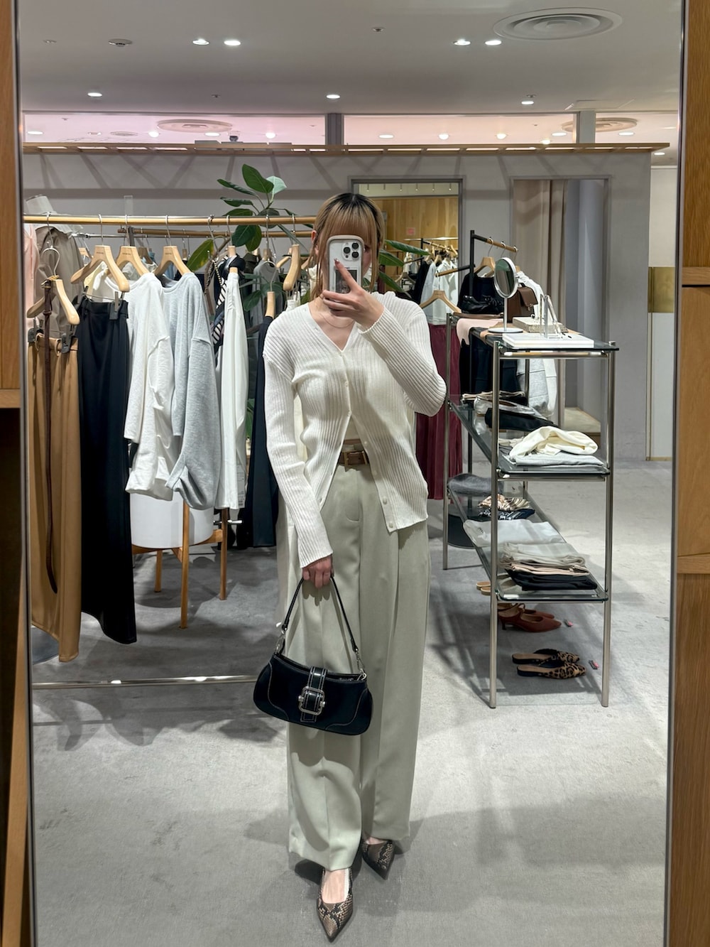 ホワイト系のカーディガン/ボレロ、ベージュ系のその他パンツ、ブラック系のハンドバッグを着用したレディースの春コーディネートの2枚目の写真