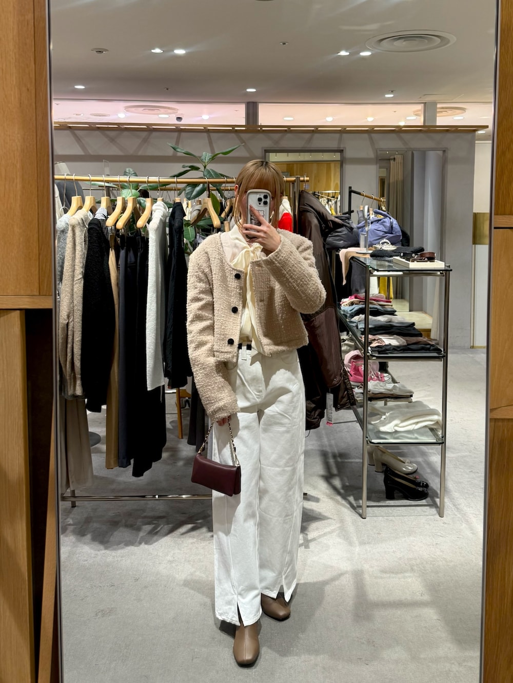 ブラウン系のブーツ、ホワイト系のデニムパンツ、ホワイト系のシャツ/ブラウスを着用したレディースの冬コーディネートの3枚目の写真