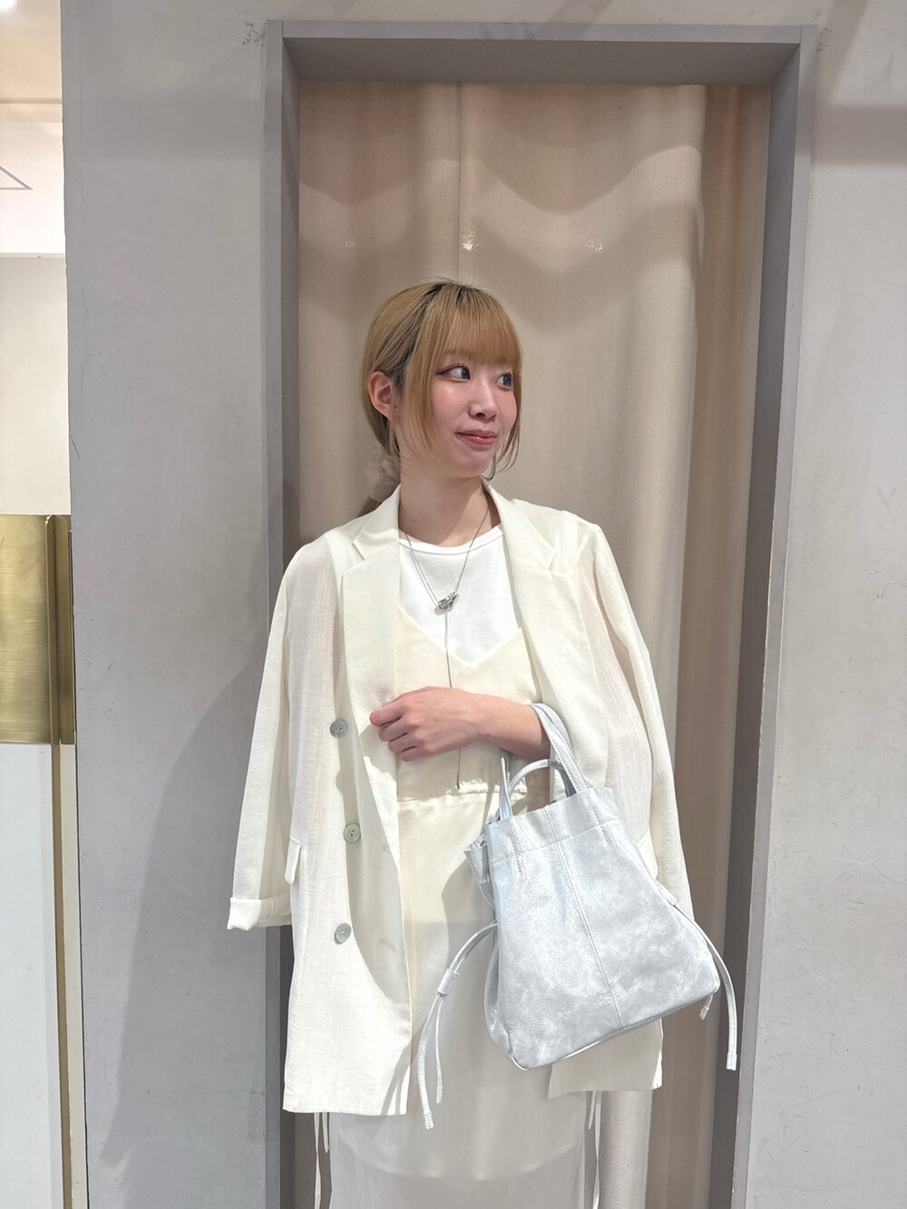 ゴールド系のサンダル、ホワイト系のTシャツ/カットソー、シルバー系のトートバッグを着用したレディースの夏コーディネートの4枚目の写真