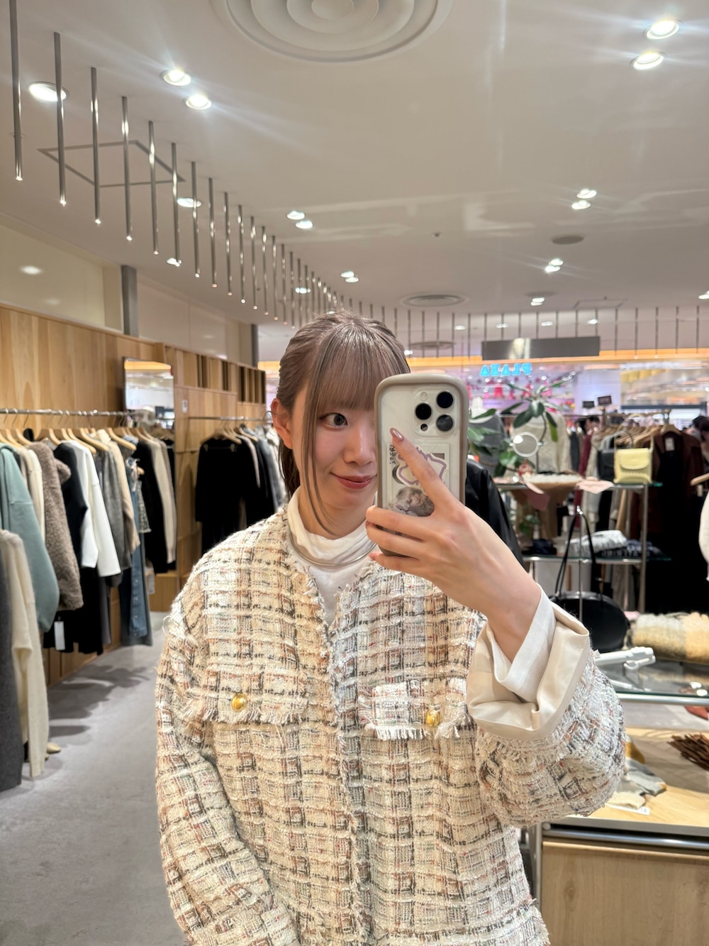 ホワイト系のその他アウター、ホワイト系のニット/セーター、ブラック系のトートバッグを着用したレディースの冬コーディネートの2枚目の写真