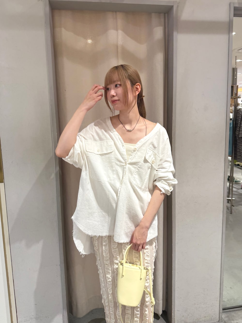 ホワイト系のシャツ/ブラウス、イエロー系のトートバッグ、ベージュ系のスカートを着用したレディースの夏コーディネートの3枚目の写真