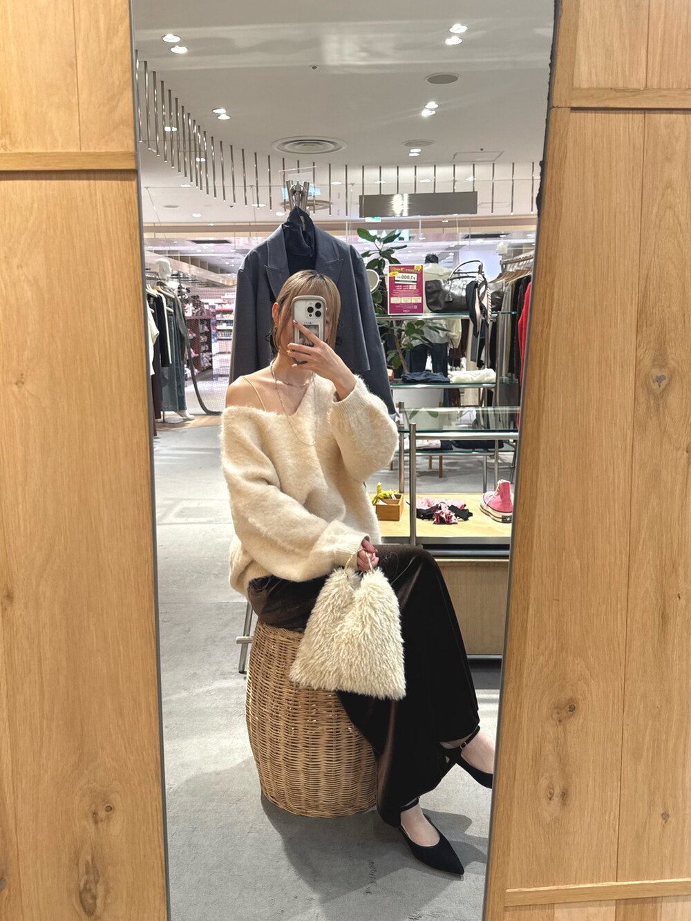 ブラウン系のスカート、ブラック系のパンプス、ホワイト系のニット/セーターを着用したレディースの秋コーディネートの2枚目の写真