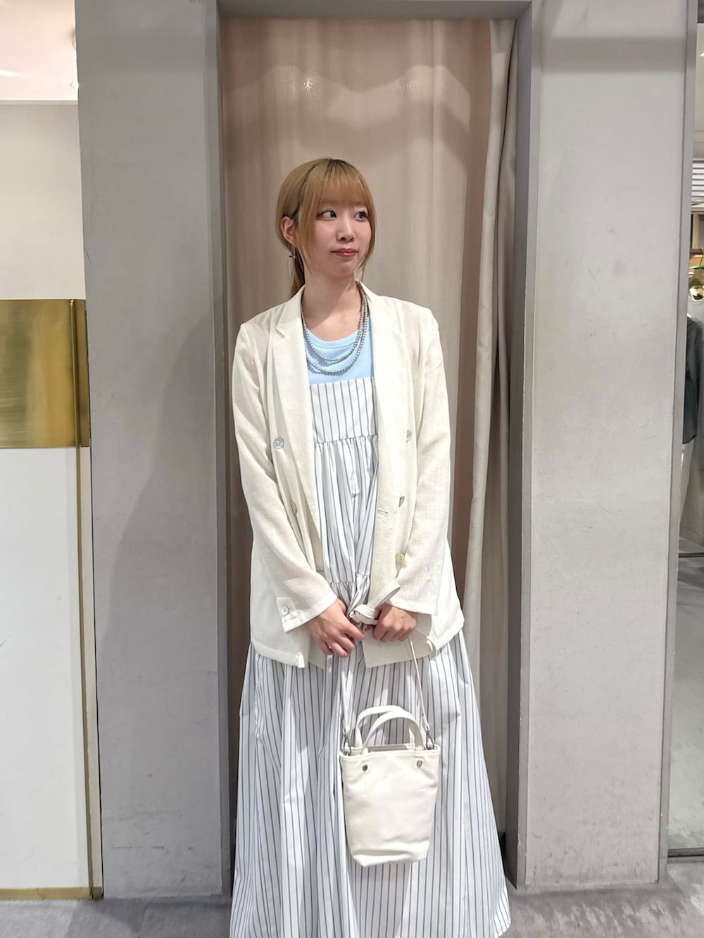 ホワイト系のトートバッグ、ホワイト系のワンピース、ホワイト系のテーラードジャケットを着用したレディースの春コーディネートの3枚目の写真